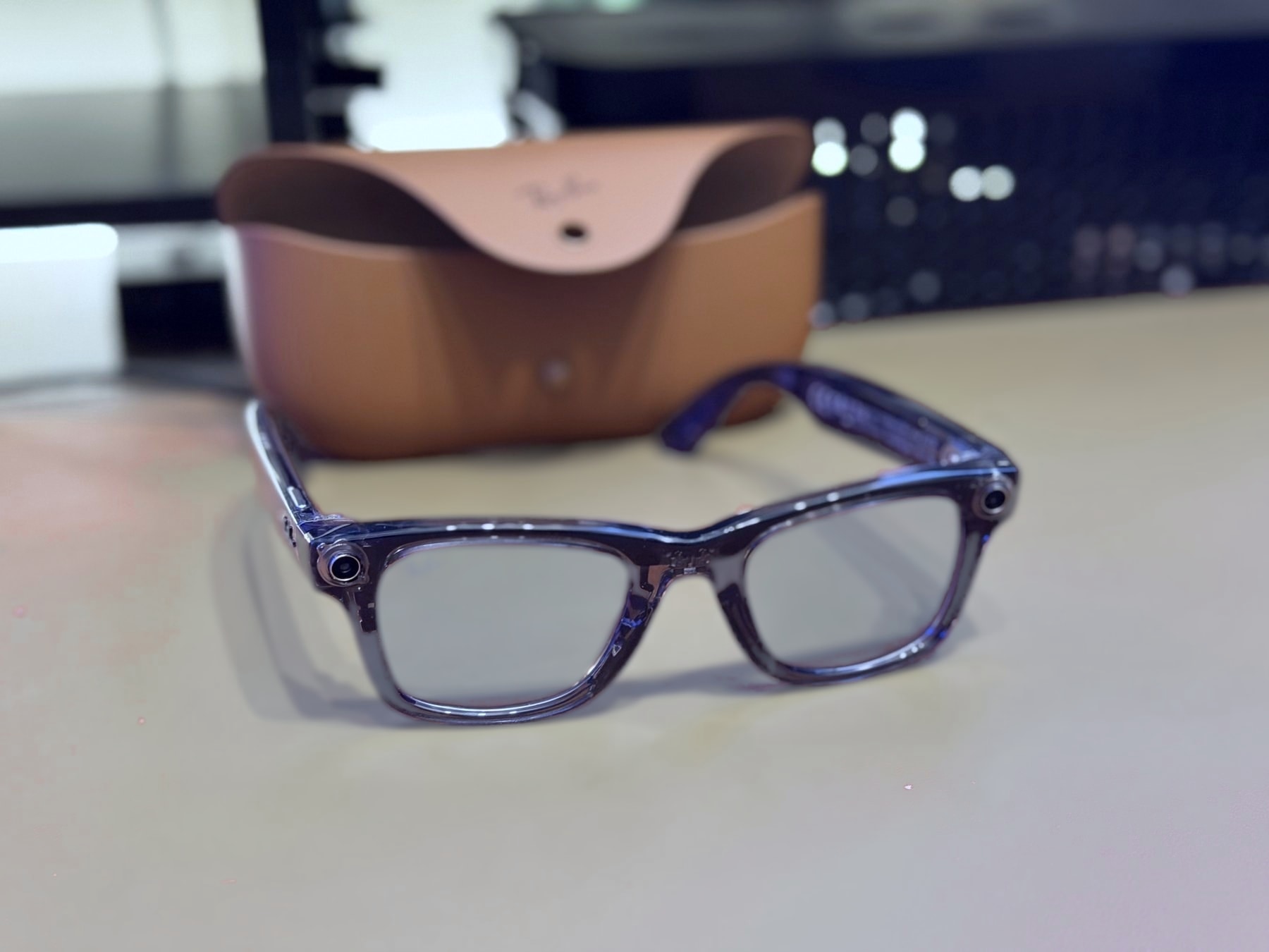 The Ray-Ban Meta Gen 2 Wayfarer on my desk, charging case behind